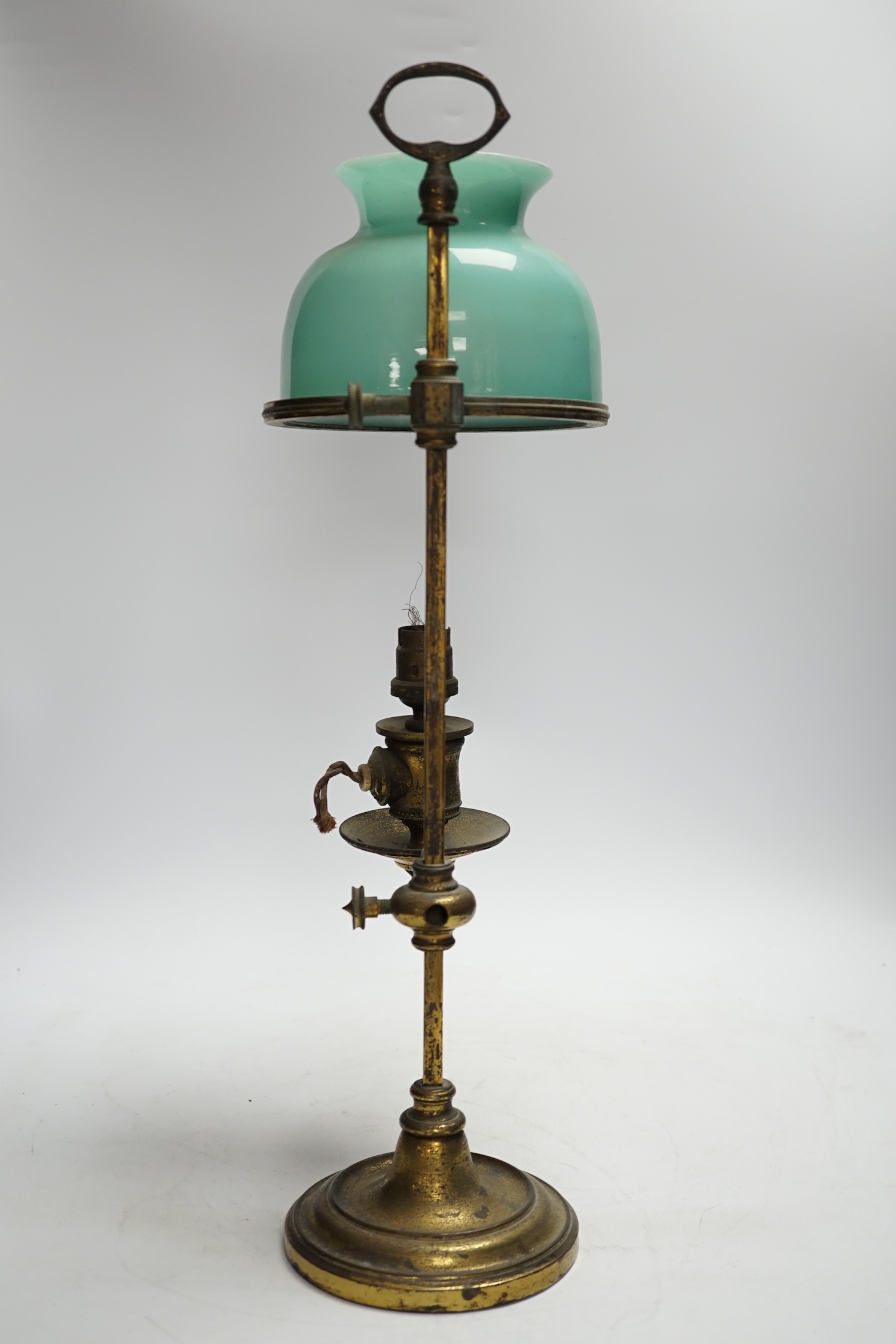 A brass desk lamp with green glass shade, circa 1920’s